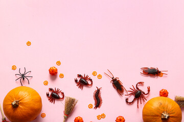 Halloween composition with candy bugs and pumpkins on pink background