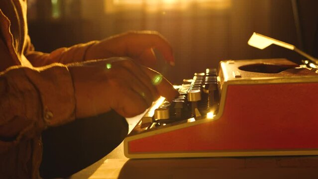 Novelist author or writer type text of new book on old retro mechanical typewriter. Make story, novel manuscript in literature. Man's hand fingers on vintage keyboard. Sunset background, warm color