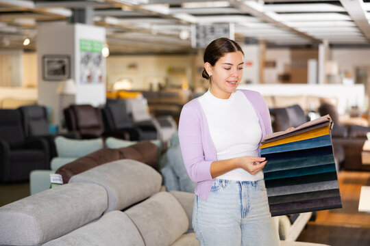 Woman picking upholstery material in furniture store