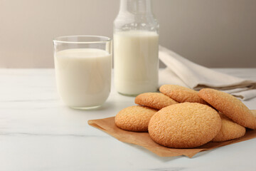 Delicious Danish butter cookies and milk on white marble table, closeup. Space for text