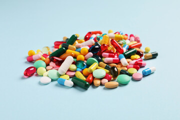 Many different pills on light blue background