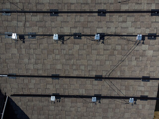 Metal racks with power optimizers for installing solar panels mounted on the shingles of...