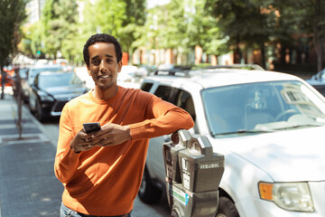 African American man holding mobile phone communication online, looking at screen