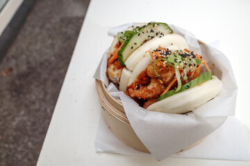 Bao buns, steamed wheat flour-based, leavened dough wrap and filled with fried Chicken, on bamboo...