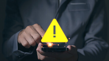 Programmer developer uses mobile phone with warning triangle sign for notification, found error and...