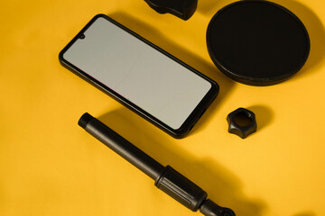 top view of smartphone with white screen and parts of stand phone or mini tripod