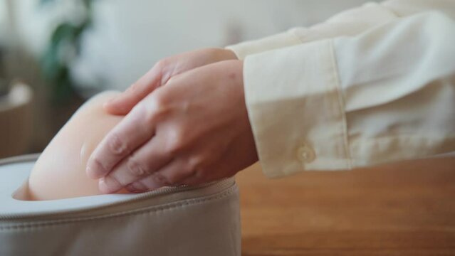 Silicone breast prosthesis in skin tone held by female hands, closeup