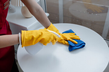 Asian woman cleaning staff, housekeeper cleaning tables in a company office, maintaining cleanliness in the office. Cleaning concept and housekeeper taking care of cleanliness and order in the office.