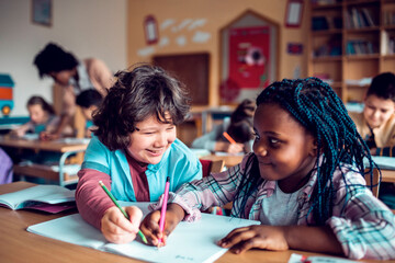 Two Young and diverse children working together on assignment in a middle school classroom