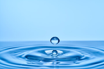 Group of water droplets fall and bounce on a water surface