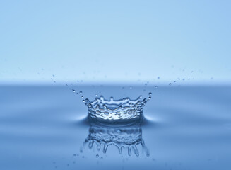 Group of water droplets fall and bounce on a water surface