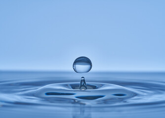 Group of water droplets fall and bounce on a water surface