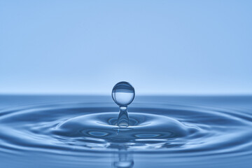 Group of water droplets fall and bounce on a water surface