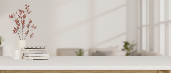 A white tabletop with books, a coffee mug, and a flower vase against a blurred modern living room.