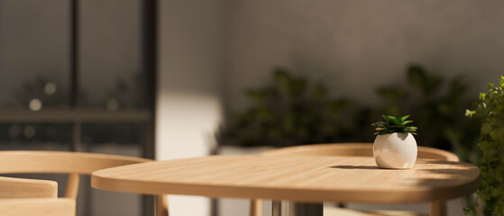 Close-up image of a copy space on a wooden table in a minimalist and cosy coffee shop.
