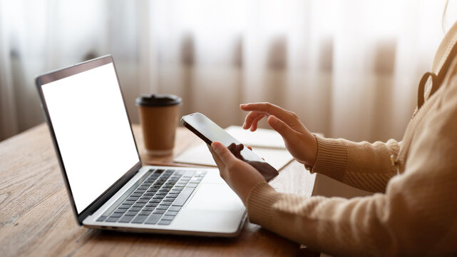 Cropped side view image of a woman using her smartphone while working remotely in a coffee shop.