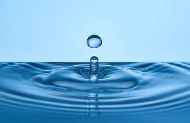 Group of water droplets fall and bounce on a water surface
