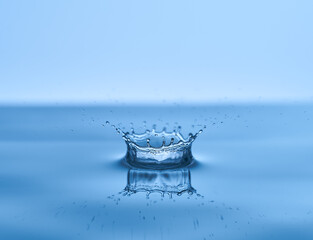 Group of water droplets fall and bounce on a water surface