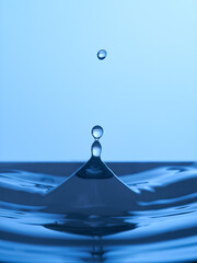 Group of water droplets fall and bounce on a water surface