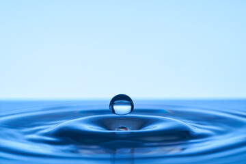 Group of water droplets fall and bounce on a water surface