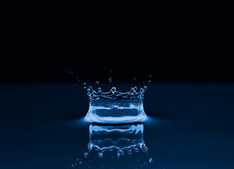 Group of water droplets fall and bounce on a water surface