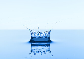 Group of water droplets fall and bounce on a water surface