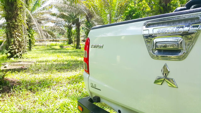 Riau, Indonesia - April 26, 2023: Mitsubishi Triton Pickup Truck in the palm oil plantation. 4X4 wheel drive car.