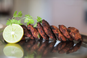 Chicken nuggets, Chicken Vada arranged in a row with coriander leaves and lemon