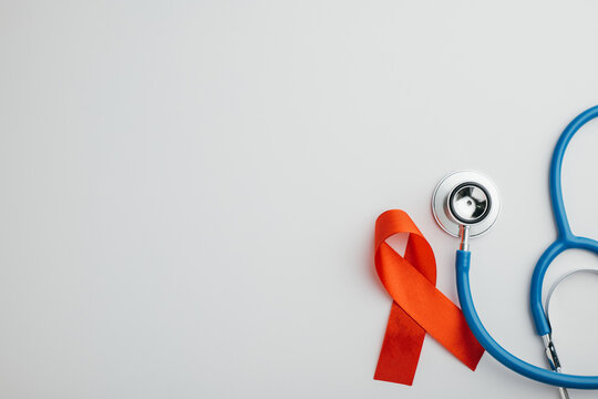 Stethoscope and red AIDS ribbons from a top view, isolated on white. Symbolizing hope and support in the fight against HIV. Give me this.