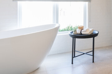 Fototapeta na wymiar Cropped view of ceramic white bathtub in modern bathroom. Interior design idea. Home spa relaxation concept.