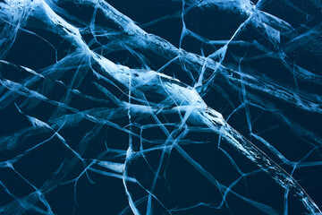 Transparent blue ice with cracks. Natural cold background of ice. 