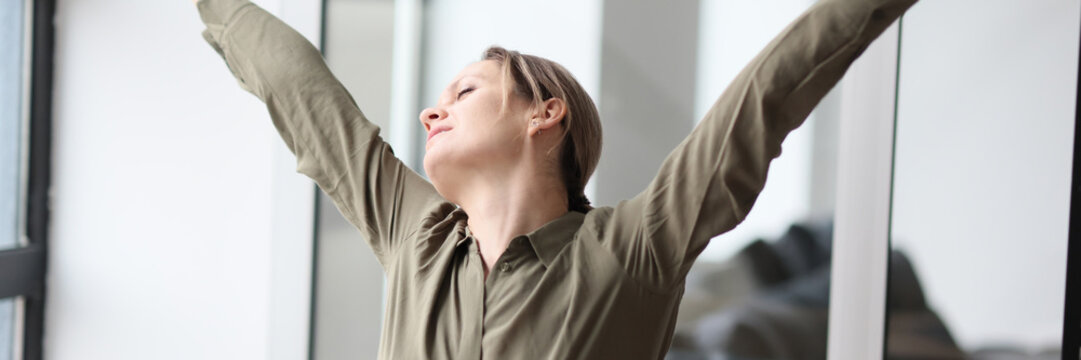 Woman stretches arms and back after monotonous work at table