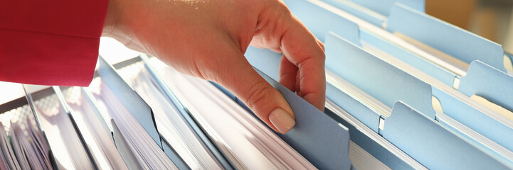 Hand of woman taking folder with necessary work materials