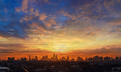 Fototapeta premium Background of orange sky with clouds and sunset in city.