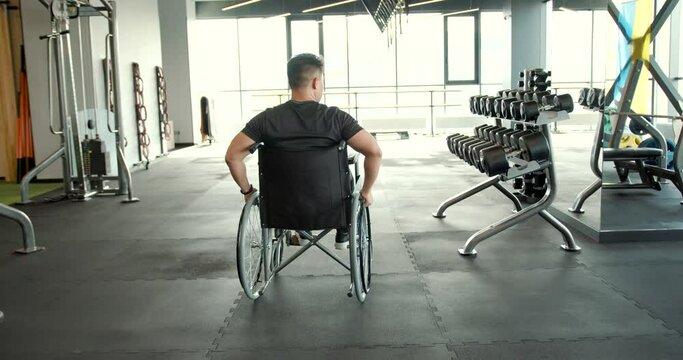 A disabled man in a wheelchair training in the gym