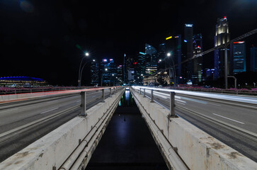 express highway leads to singapore city down town city central district in night time, highway bridge with many skyscraper financial buildings in background during rush hour