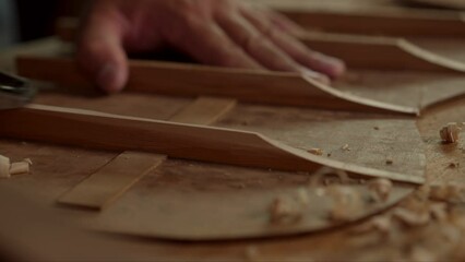Guitar luthier using small planer to fine-tune bracing of acoustic guitar.