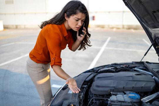 Woman opening car hood and look for trouble car breaks down and wating for insurance or someone to help after the car breaks down, park on the side of the road. Transportation accident concept.