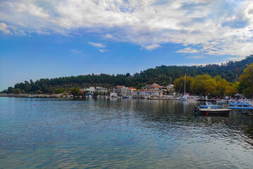 Fototapeta na wymiar Limenas City in Thassos Island , Greece , the main city of the island with the harbor and pier , and the pine forest behind