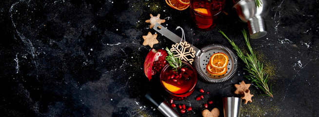 Winter christmas cocktail with pomegranate and rosemary in a glasses on black background. Top view