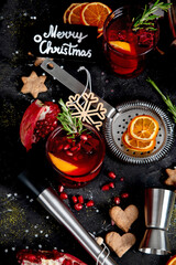 Winter christmas cocktail with pomegranate and rosemary in a glasses on black background. Top view