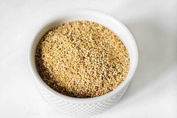 White quinoa on the white plate on the white background. Healthy food and nutrition concept. Safe, ecological, and healthy products