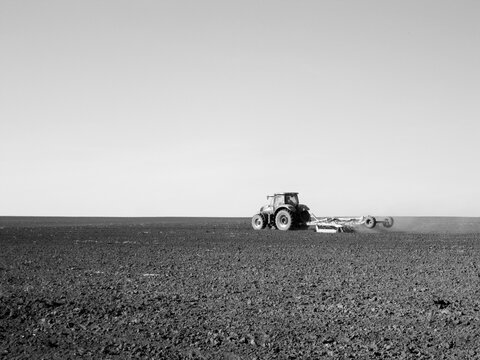 Plowed field by tractor in black soil on open countryside nature - Powered by Adobe