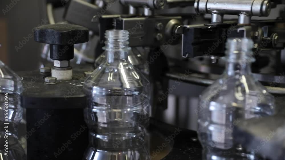 Poster close up of empty vinegar bottles at a factory rotating under automated machinery.