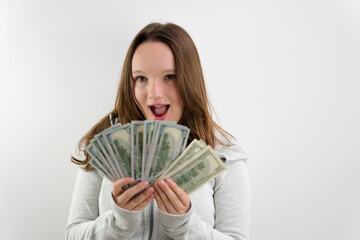 happy woman showing dollar bills money and smiling isolated on grey background. High quality photo