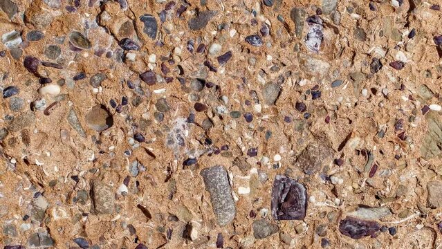 Rock with inclusions of different minerals rotating, turning, close-up macro, top view
