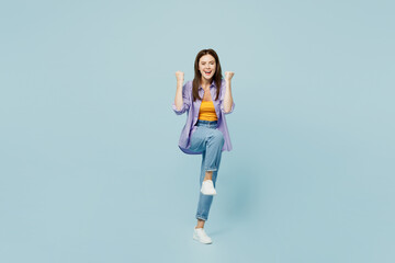 Fototapeta na wymiar Full body young happy woman she wears purple shirt yellow t-shirt casual clothes doing winner gesture celebrate clenching fists say yes isolated on plain pastel light blue background studio portrait.