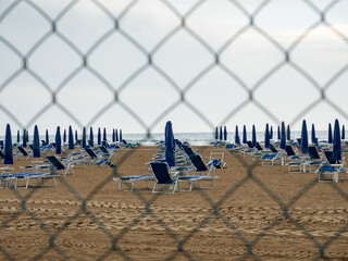 Closed beach parasol at empty seaside coast. Beach in Italy - 653587402