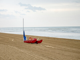 Wet sunbeds and umbrellas on the sea beach during rainy day. - 653587404