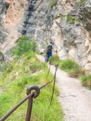 Rope and shackles anchored in hard dolomite limestone rock. Climbers path via ferrata. - 653587644